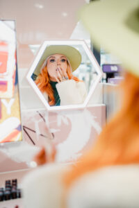 woman in mirror doing make-up
