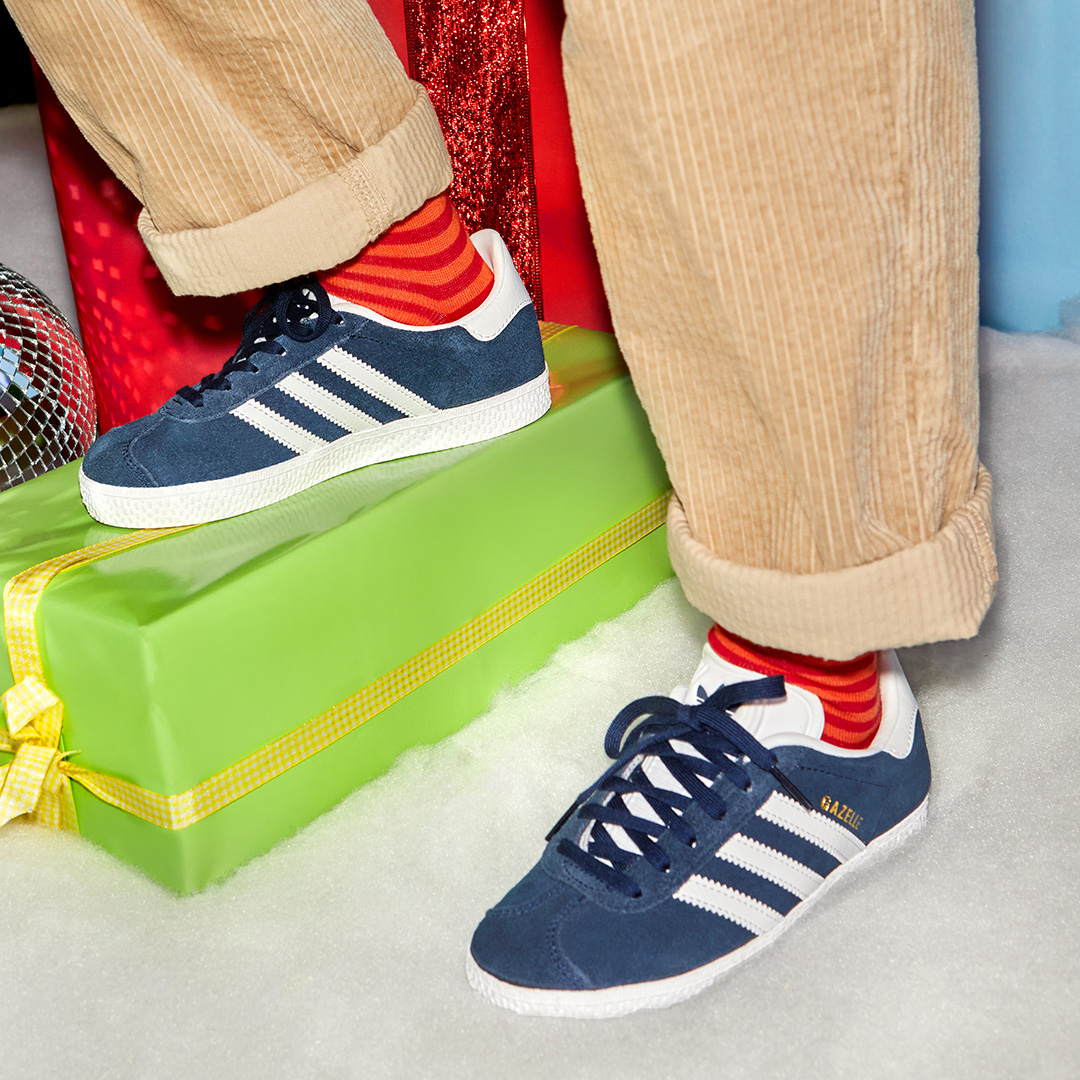 Child navy Gazelle trainers standing on present 