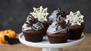 Rich Halloween-themed chocolate cupcakes with spider and spiderweb decorations for festive celebrations.